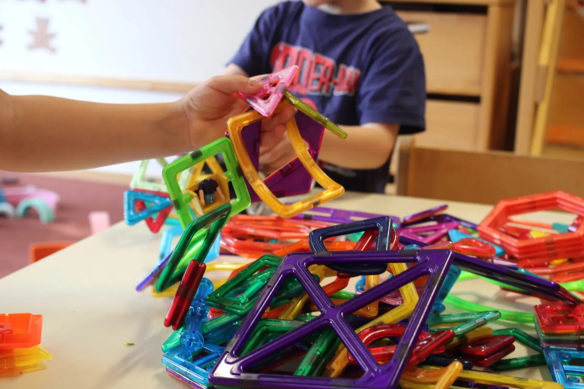 Kinder spielen mit Magnetbausteinen